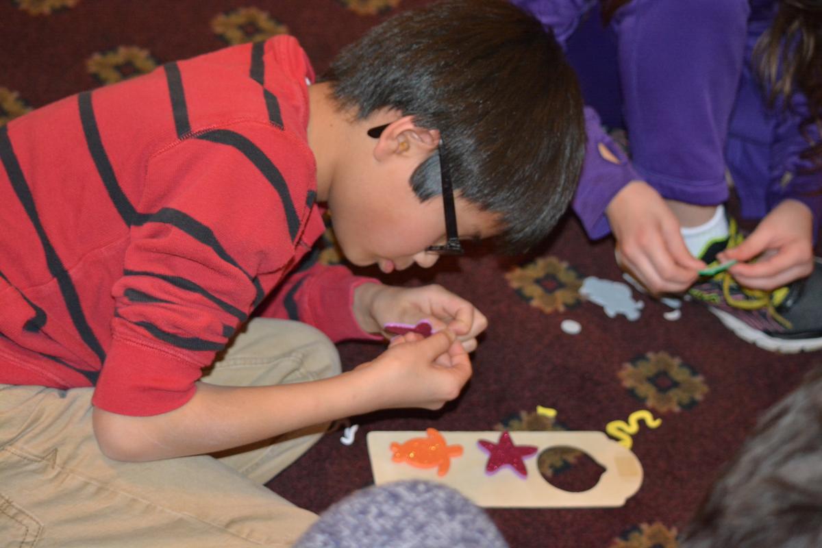 A young boy works on his artwork.
